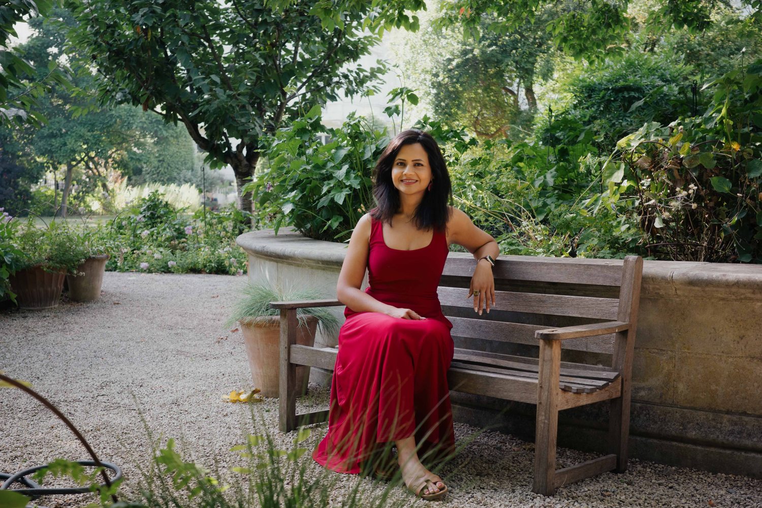Ankita Neotia seated on a bench in a London garden