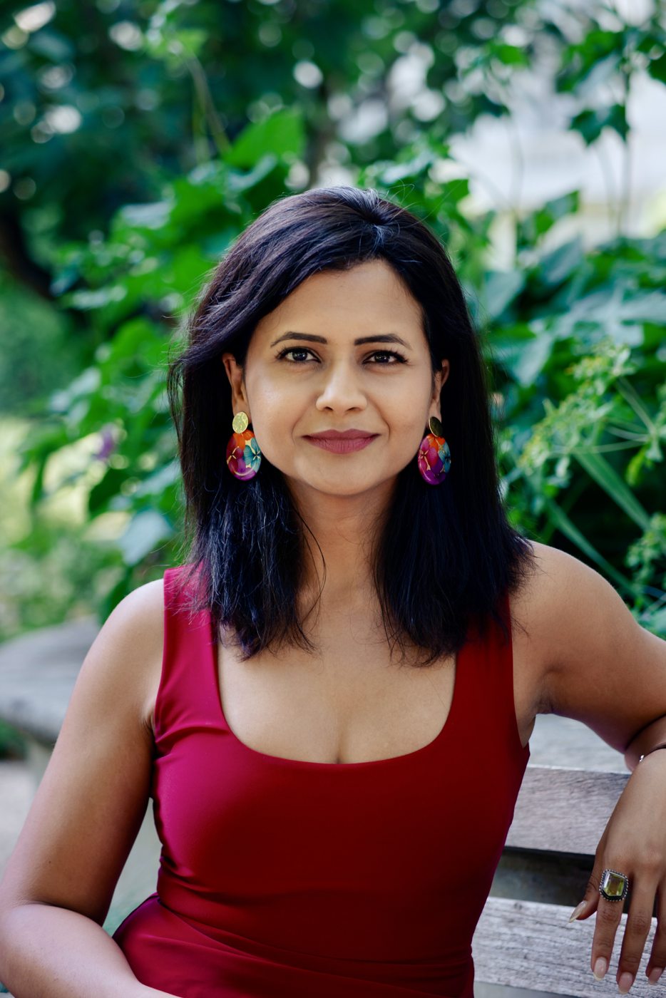 Portrait of Ankita Neotia in a red dress in a London garden