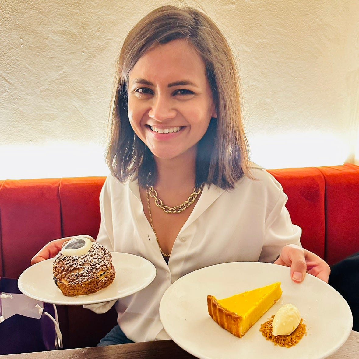 Ankita Neotia smiling and holding two plates of dessert