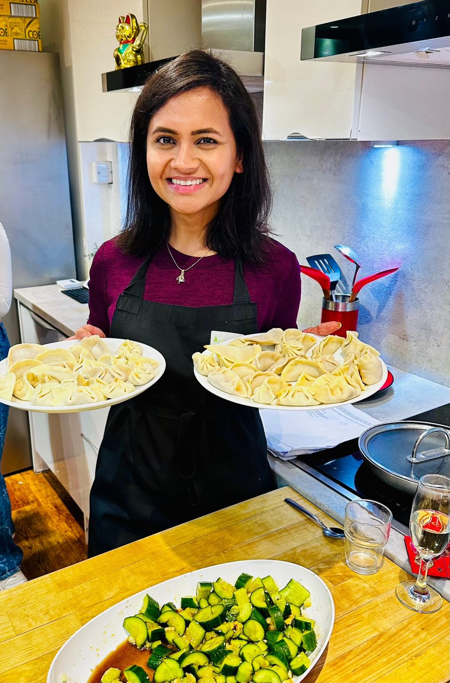 Ankita in an apron serving plates at The Elsewhere Club, her London supper club