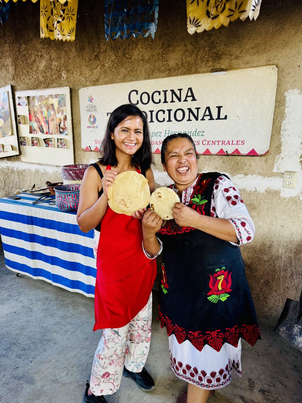 Ankita with a traditional cook at a cocina tradicional in Oaxaca, holding fresh tortillas