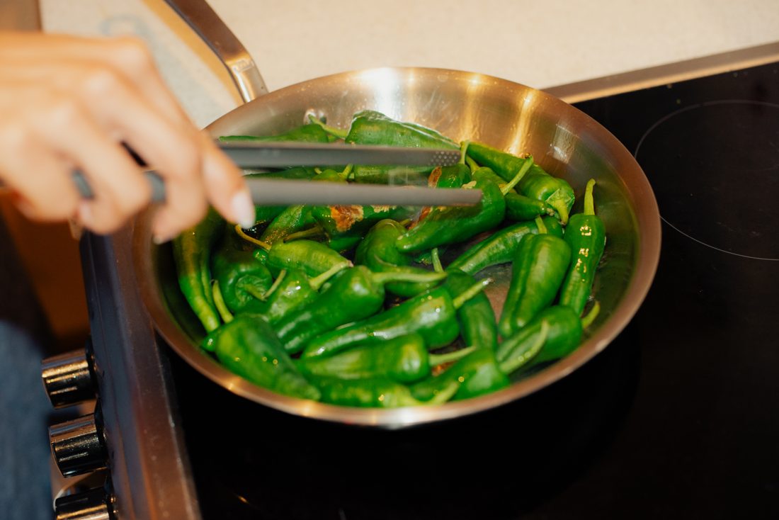 Tossing padron peppers on the stove