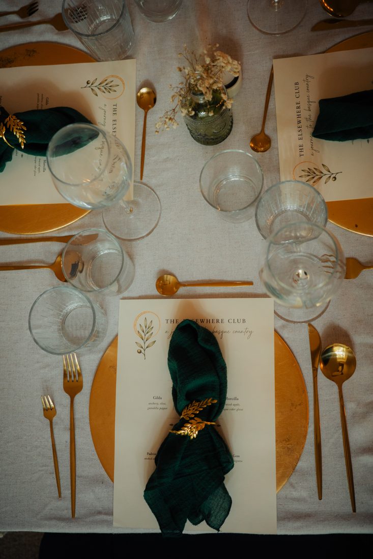 Place setting with green napkin and gold cutlery